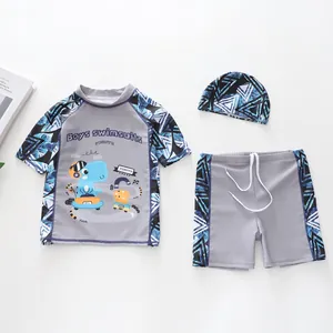 Détail à plat du maillot de bain dinosaure trois pièces pour garçons avec haut et bonnet