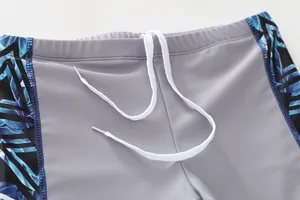 Détail de la taille du maillot de bain garçon avec imprimé feuilles et cordon blanc