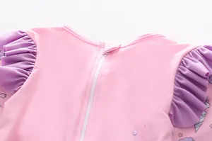 Detail eines rosa Mädchen-Badeanzugs mit verstecktem Reißverschluss und lila Rüschen