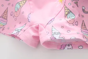 Detailaufnahme von rosa Kinderbadeanzugstoff mit Einhorn- und Regenbogen-Cartoon-Prints