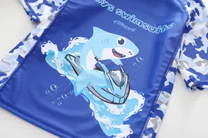 Détail du haut de bain garçon avec motif requin et manches camouflage bleu vif