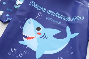 Détail du maillot de bain garçon bleu foncé montrant coutures et motif requin