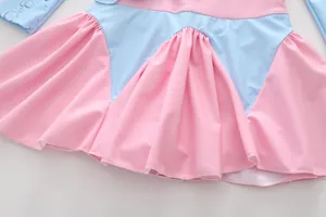 Détail d'un maillot de bain fille rose et bleu avec ourlet volanté et motifs gouttes