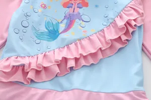Détail de l'imprimé sirène et des volants roses sur ce maillot de bain pour filles
