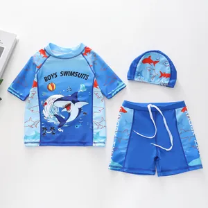 Detailoverzicht van driedelig kinderzwempak met haaienprint en bijpassende badmuts
