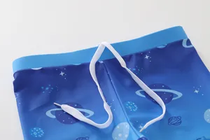 Détail du short de bain enfant avec taille élastique, cordon blanc et imprimé espace