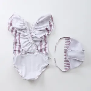 Detail view of purple striped girls' swimsuit with ruffled neckline and matching swim cap