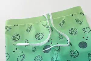 Détail du short de bain enfant avec dégradé vert, cordon de serrage et motif spatial