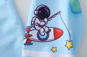 Détail de l'imprimé astronaute et fusée sur le maillot de bain bleu pour enfants