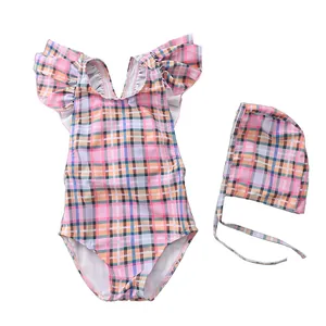 Pink checkered girl's swimsuit set with ruffled shoulders and matching swimming cap