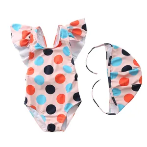 Close-up of pink toddler swimsuit with colorful polka dots and ruffled shoulder straps
