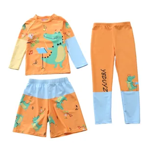 Dettaglio dell'abbigliamento da nuoto per bambini a tema coccodrillo navy con accenti arancio