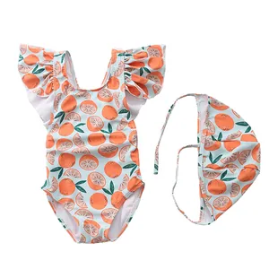 Detail of girls one-piece swimsuit with orange prints and matching swim cap set