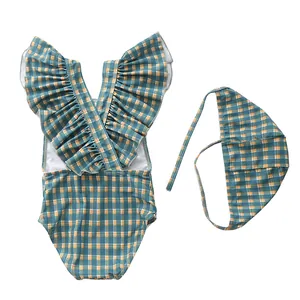 Detailed flat lay of striped girls one-piece swimsuit and matching tie-up swim cap
