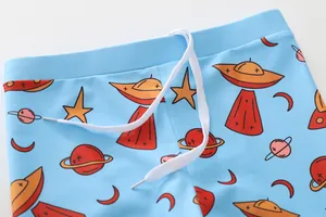 Détail de short de bain bleu ciel pour garçon avec motif spatial et cordon blanc