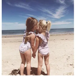 Girls one-piece striped and floral ruffles swimsuits on beach with back view design
