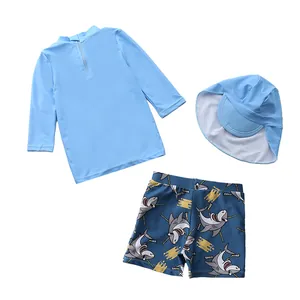 Détail de l'ensemble de bain enfant 3 pièces avec imprimé requin et bonnet de soleil