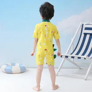 Rear view of yellow children's swimsuit featuring green fin details and back zipper