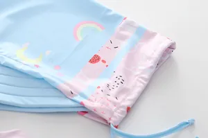 Détail du tissu de maillot de bain avec imprimés arc-en-ciel et coutures roses soignées