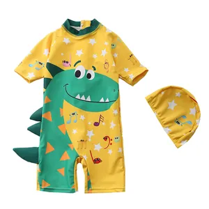 Flat lay of yellow long-sleeved kids one-piece swimsuit with dinosaur print and matching cap
