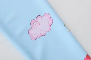 Gros plan du tissu de maillot de bain bleu ciel avec motifs de nuages roses en spirale