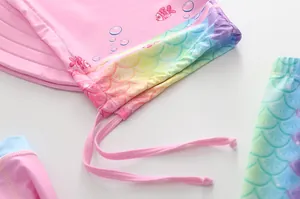 Détail de maillot de bain rose pour fille avec motif écailles arc-en-ciel et cordon rose