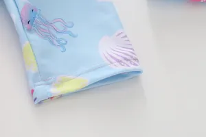 Detail der flachen Naht am Ärmel eines hellblauen Mädchen-Badeanzugs mit Druck