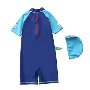 Detail view of boys cartoon dinosaur swimsuit with 3D green tail and hooded swim cap