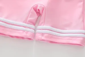 Details von rosa Mädchen-Badeshorts mit sportlichen weißen Streifen und Flachnähten