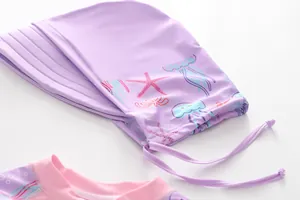 Détail du bonnet de bain violet pour enfants avec motifs marins et col rose contrasté