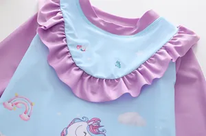 Dettaglio dello scollo con ruches viola e stampa unicorno su costume bimba