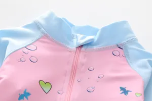 Nahaufnahme des Kinder-Langarmbadeanzugs mit Frontreißverschluss und bunten Wasserprints