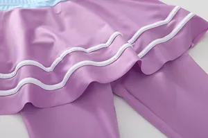 Dettaglio dei pantaloni da nuoto viola per bambina con vita azzurra e linee ondulate