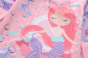Détail des imprimés sirène et méduse sur le tissu extensible d'un maillot de bain rose