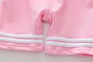 Detailaufnahme des rosa Badeanzug-Saums mit sauberer Naht und weißem Streifenbesatz