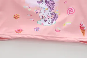 Dettaglio del tessuto rosa con motivo a cartoni di unicorno, arcobaleno e dolci
