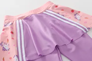 Dettaglio gonna nuoto bambina rosa e viola con stampe cartoon di unicorni e dolci