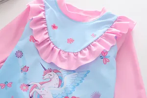 Dettaglio del costume da bagno bimba a maniche lunghe con balze rosa e unicorno