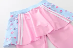 Dettaglio del costume da bagno bimba in rosa con balze a stampa unicorno e floreale