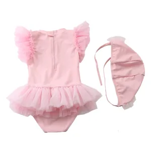 Costume da bagno rosa per bambina con maniche a volant e cappello coordinato su sfondo bianco