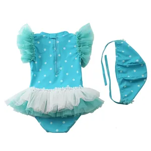 Dettaglio del costume da bagno blu a pois per bambina con gonna in tulle e cuffia abbinata
