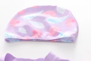 Detail of lavender purple kids swim cap with cute seashell print and elastic flat stitching