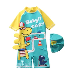 Detail view of boys cartoon dinosaur swimsuit with 3D fins and matching swimming cap