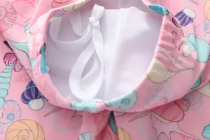 Détail du short de bain fille rose avec imprimé coquillage, cordon blanc et doublure filet