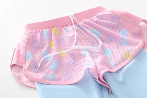 Detail of pink mesh shorts with colorful paw prints and blue inner liner for girls