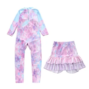 Detail of girls' long-sleeve surf swimsuit with pink marble print and ruffled skirt