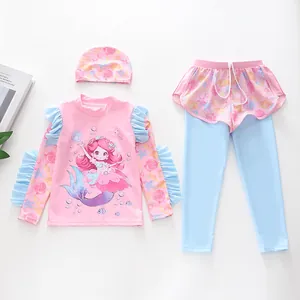 Flat lay of pink and blue girls' three-piece swimsuit set with mermaid print and swim cap