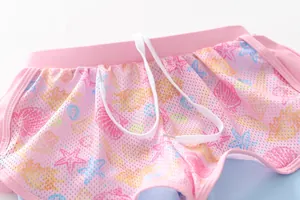 Close-up of pink breathable mesh swim shorts for girls with sea shell prints and drawstrings