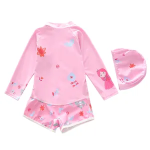 Close-up of pink long-sleeve kids swimwear with floral print and matching swimming cap