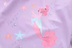 Close-up of lilac swimwear fabric with mermaid, starfish, and bubble patterns